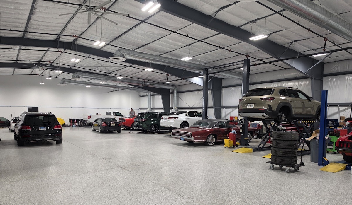 interior | Total Recon Auto repair shop interior with multiple cars on lifts, tires stacked nearby, and equipment scattered around